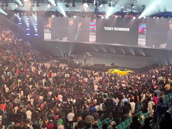 Tony Robbins presenting on the main stage at PHP Lights Out 2026, his name displayed on the arena screens