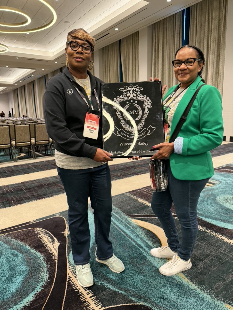 Winsome Bailey holding her Elite Money Movement plaque alongside a fellow attendee at PHP Lights Out 2026