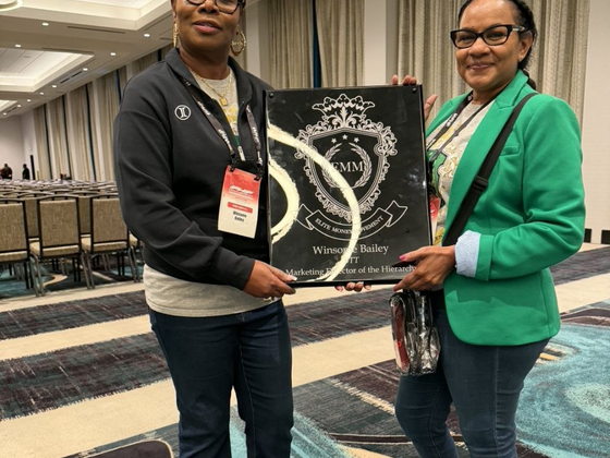 Winsome Bailey holding her Elite Money Movement plaque alongside a fellow attendee at PHP Lights Out 2026